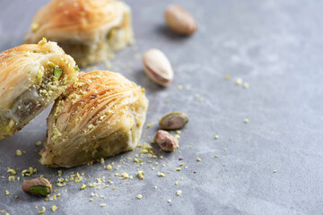 Baklava with pistachios on grey background. Jewish, turkish, arabic traditional national dessert. Macro. Selective focus. Copy space. Eastern sweets, turkish delight