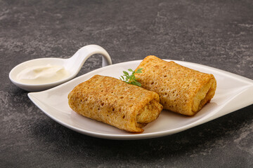 Staffed pancakes served sour cream