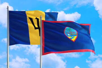 Guam and Barbados national flag waving in the windy deep blue sky. Diplomacy and international relations concept.