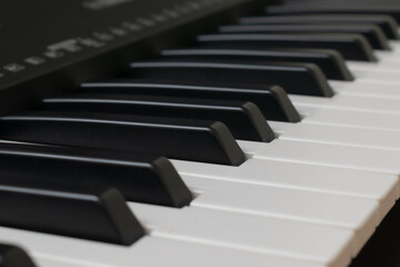 Piano keyboard. Musical background. Piano with a red gift.