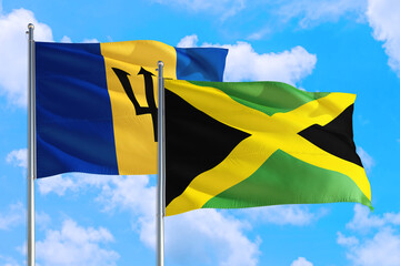 Jamaica and Barbados national flag waving in the windy deep blue sky. Diplomacy and international relations concept.