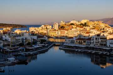Fototapeta na wymiar Beautiful late even sunlight illuminating buildings in the centre of the Cretan town of Agios Nikolaos