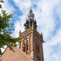 Fototapeta na wymiar Bottom up view of the church clock tower against a cloudy sky