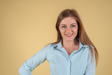 Portrait of a beautiful young woman wearing blue t-shirt isolated on yellow background