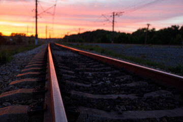 Fototapeta na wymiar railway rails during sunset with reflections on the metal