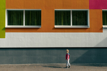 Little boy near the building with painted wall