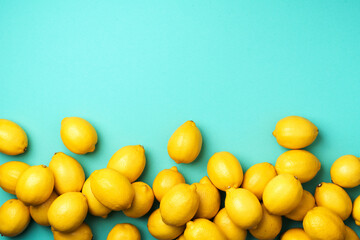 Immune system booster. Fresh lemons pattern on blue background. Copy space. Top view. Flat lay. Citrus fruits. Vitamins for health. Liposomal vitamin C. Lemon for vegan, vegetarian alkaline diet