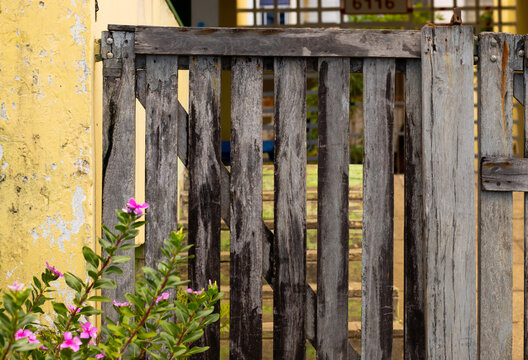 port&atilde;o velho e r&uacute;stico de madeira dando acesso a uma casa de praia 