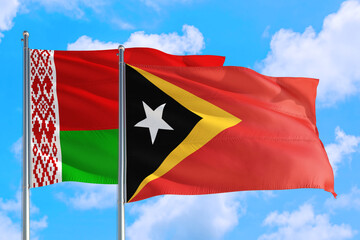 Fototapeta na wymiar East Timor and Belarus national flag waving in the windy deep blue sky. Diplomacy and international relations concept.