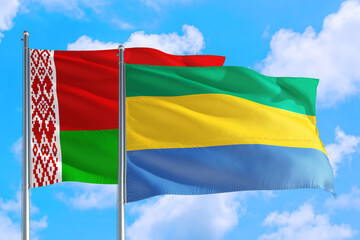 Gabon and Belarus national flag waving in the windy deep blue sky. Diplomacy and international relations concept.