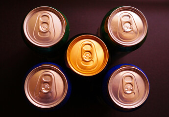 Five cans of beer on black background.