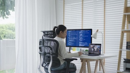 Back rear view of young asian woman, freelance data scientist work remotely at home coding programing on Big data mining, AI data engineering, IT Technician Works on Artificial Intelligence Project. - Powered by Adobe