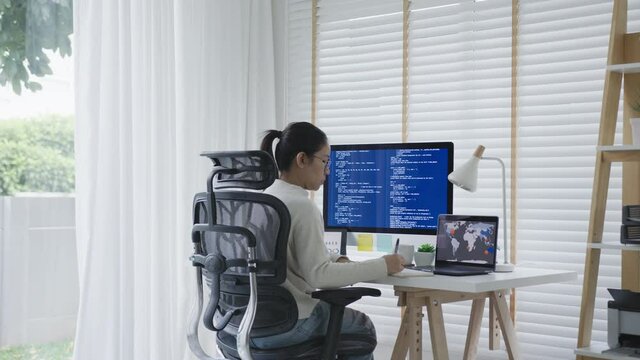Back rear view of young asian woman, freelance data scientist work remotely at home coding programing on Big data mining, AI data engineering, IT Technician Works on Artificial Intelligence Project.