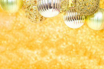 Christmas Shining gold background, with golden Christmas Balls ans Baubles, on Glittering Gold Bokeh Background, copy space