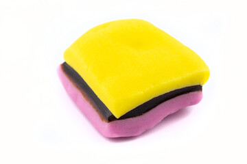 Yellow and pink marzipan candy with liquorice inside, isolated on a white background.