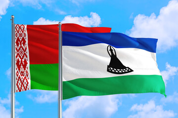 Naklejka na ściany i meble Lesotho and Belarus national flag waving in the windy deep blue sky. Diplomacy and international relations concept.