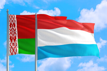 Luxembourg and Belarus national flag waving in the windy deep blue sky. Diplomacy and international relations concept.
