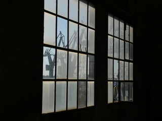 Shipyard cranes seen through cut-up window, Gdańsk Shipyard, Poland