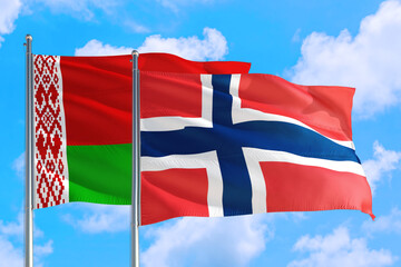 Norway and Belarus national flag waving in the windy deep blue sky. Diplomacy and international relations concept.