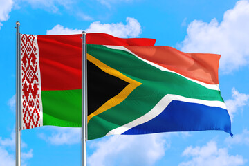 South Africa and Belarus national flag waving in the windy deep blue sky. Diplomacy and international relations concept.