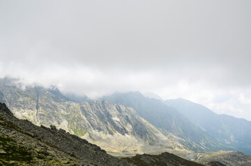 Obraz premium Mountain peaks, low clouds and fog. High Tatras Mountains in Slovakia