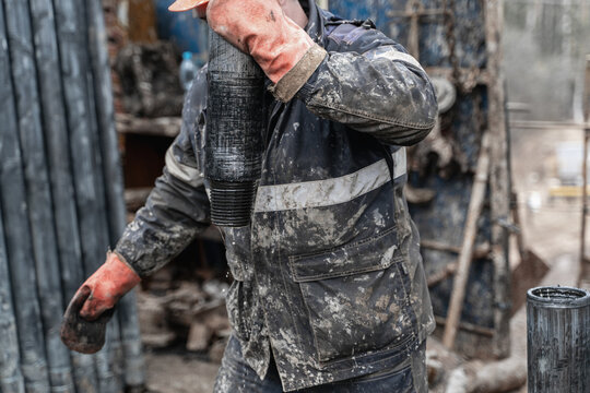 Offshore oil rig worker prepare tool and equipment for perforation oil and gas well at wellhead platform. Making up a drill pipe connection. A view for drill pipe connection from between the stands