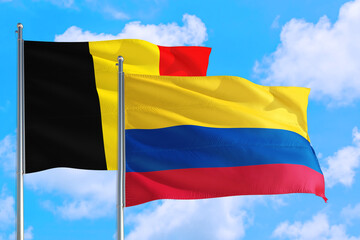 Colombia and Belgium national flag waving in the windy deep blue sky. Diplomacy and international relations concept.