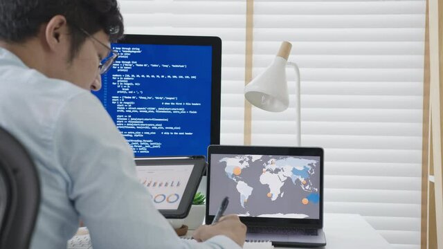 Back rear view of young asian man, freelance data scientist work remotely at home coding programing on Big data mining, AI data engineering, IT Technician Works on Artificial Intelligence Project.