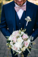 Blumenstrauss in den Händen des Bräutigams am Hochzeitstag