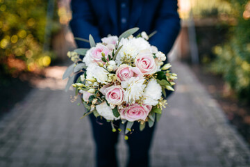 Blumenstrauss in den Händen des Bräutigams am Hochzeitstag