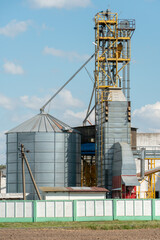 Obraz premium silver silos on agro manufacturing plant for processing drying cleaning and storage of agricultural products, flour, cereals and grain. Large iron barrels of grain. Granary elevator