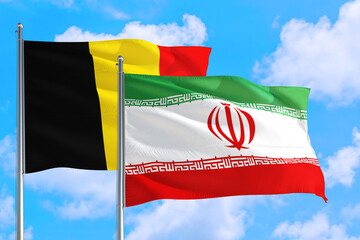 Iran and Belgium national flag waving in the windy deep blue sky. Diplomacy and international relations concept.