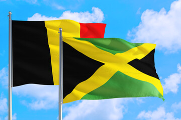 Jamaica and Belgium national flag waving in the windy deep blue sky. Diplomacy and international relations concept.