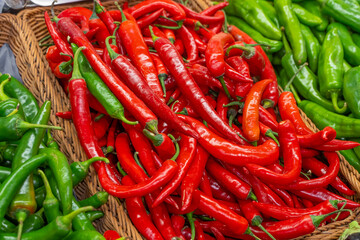 Vegetables on greengrocer counter. Red and green chillies close-up. Used in vegetable dishes.