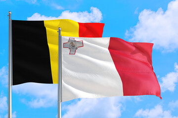 Malta and Belgium national flag waving in the windy deep blue sky. Diplomacy and international relations concept.