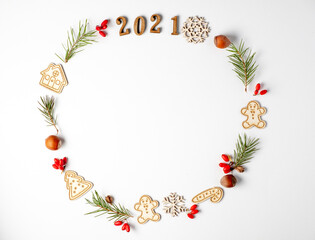 Happy new year 2021. Christmas round frame, decorative border. Winter composition of numbers 2021, fir branches, red berries on a white background. Flat lay and copy space.
