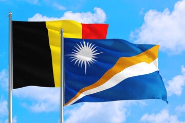 Marshall Islands and Belgium national flag waving in the windy deep blue sky. Diplomacy and international relations concept.