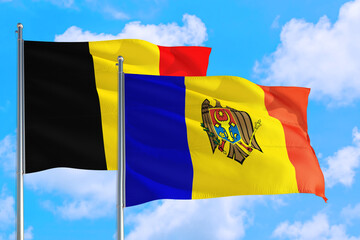 Moldova and Belgium national flag waving in the windy deep blue sky. Diplomacy and international relations concept.