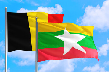 Myanmar and Belgium national flag waving in the windy deep blue sky. Diplomacy and international relations concept.