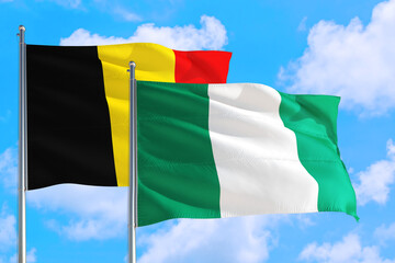 Nigeria and Belgium national flag waving in the windy deep blue sky. Diplomacy and international relations concept.
