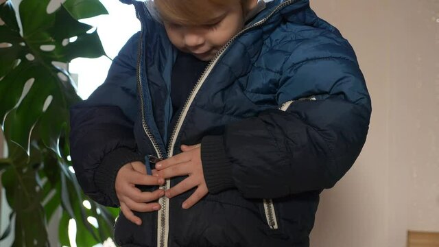 Cute Child Zipping his own Jacket. Little Boy Wearing Winter Attire. 2x Slow motion 60 fps 4K