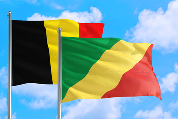 Republic Of The Congo and Belgium national flag waving in the windy deep blue sky. Diplomacy and international relations concept.