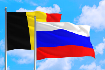 Russia and Belgium national flag waving in the windy deep blue sky. Diplomacy and international relations concept.