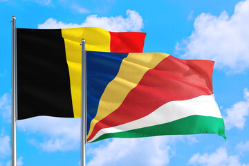 Seychelles and Belgium national flag waving in the windy deep blue sky. Diplomacy and international relations concept.