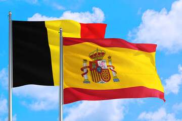 Spain and Belgium national flag waving in the windy deep blue sky. Diplomacy and international relations concept.