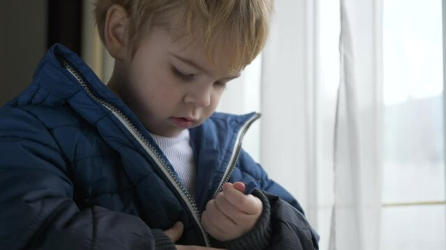 Child with Struggle Tries to Zip Jacket. Mother Helps to Fasten with a Zipper. Little Boy Wearing Winter Attire. Zipping with Zip-fastener. 2x Slow motion 60 fps 4K