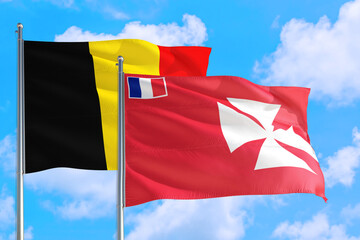 Wallis And Futuna and Belgium national flag waving in the windy deep blue sky. Diplomacy and international relations concept.