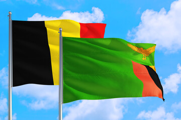 Zambia and Belgium national flag waving in the windy deep blue sky. Diplomacy and international relations concept.