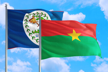 Burkina Faso and Belize national flag waving in the windy deep blue sky. Diplomacy and international relations concept.