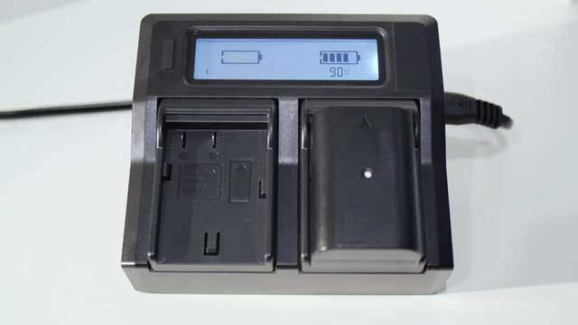 Man hand instaling battery on black charger with LED display